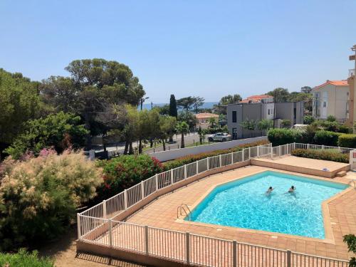 - une piscine avec 2 personnes dans l'eau dans l'établissement Apartment Newly Renovated Aircond-wifi-pool-sea View-150m to Beaches- Saint Aygulf, à Saint-Aygulf
