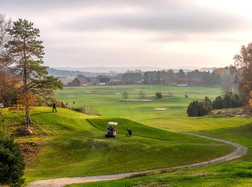 a golf course with a golf cart on a green at Kungälv-Kode Golf Club Bed & Breakfast in Kode