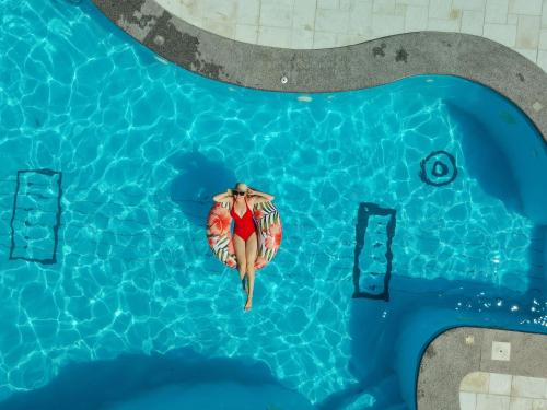 an overhead view of a woman swimming in a swimming pool at Foton Hotel & Restaurant in Ochakiv