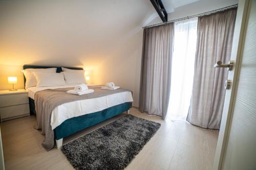 a bedroom with a bed and a large window at Apartman Star in Arandjelovac