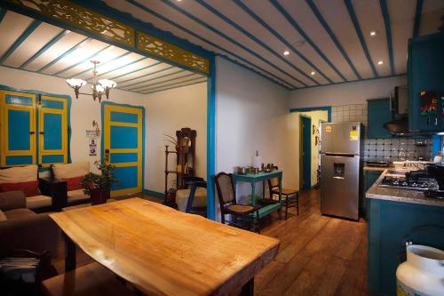 a living room with a wooden table and a kitchen at Real House Salento in Salento