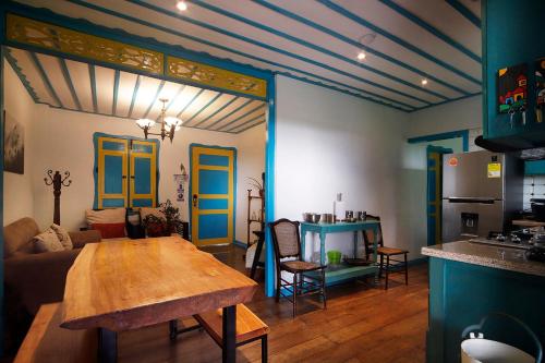 a living room with a table and a kitchen with blue doors at Real House Salento in Salento