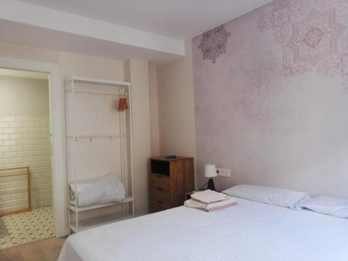 1 dormitorio con 1 cama blanca y 1 silla en PRECIOSO APARTAMENTO JUNTO A LA ALHAMBRA EN PLENO CENTRo en Granada
