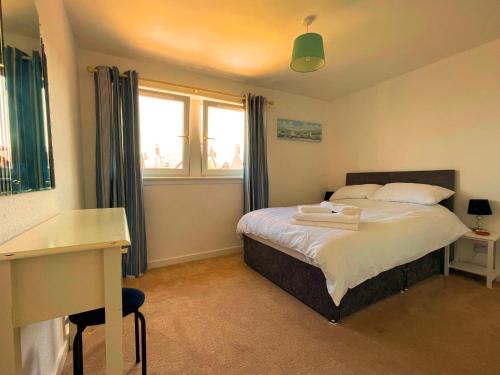 een slaapkamer met een bed, een bureau en een raam bij Spacious 2 Bedroom Home in Picturesque Cullen in Cullen