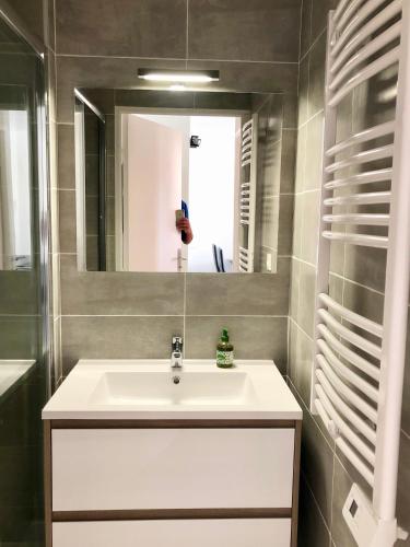 une salle de bain avec un lavabo blanc et un miroir dans l'établissement Apartment Newly Renovated Aircond-wifi-pool-sea View-150m to Beaches- Saint Aygulf, à Saint-Aygulf