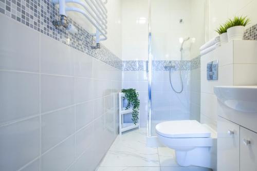 biała łazienka z toaletą i umywalką w obiekcie RJ Hostel Chrobrego 79 w Gdańsku