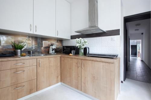 a kitchen with wooden cabinets and a counter top at RJ Hostel Chrobrego 79 in Gdańsk