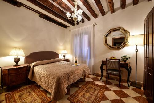 a bedroom with a bed and a table and a mirror at Anzolo Palace - Rooms & Apartments in Venice