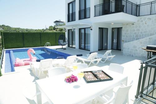 a villa with a swimming pool and a white table and chairs at Villa myra in Demre