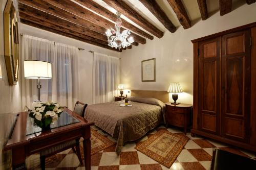 a bedroom with a bed and a table and two lamps at Anzolo Palace - Rooms & Apartments in Venice