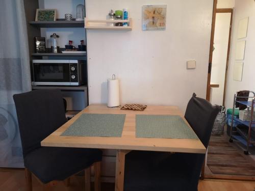 a wooden table with two chairs and a microwave at Apartman Myra in Zagreb