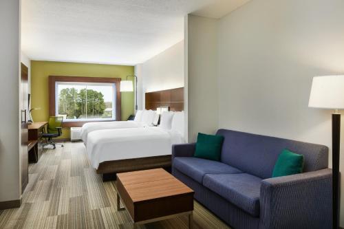 una camera d'albergo con letto e divano di Holiday Inn Express Palatka Northwest, an IHG Hotel a Palatka