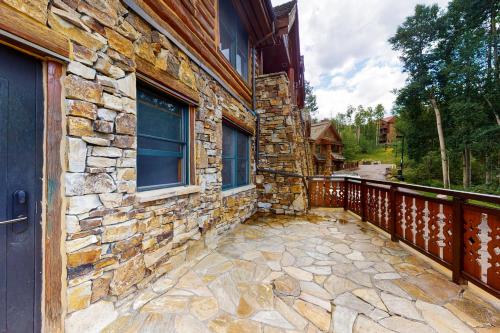 特柳賴德的住宿－Mountain Lodge，石头房子,带木栅栏的门廊