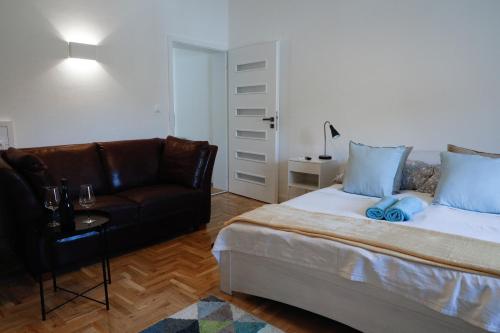 um quarto com uma cama e um sofá de couro em Apartman 3 em Komárom