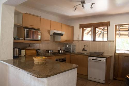 a kitchen with wooden cabinets and a counter top at Kruger Park Lodge Unit 245 in Hazyview