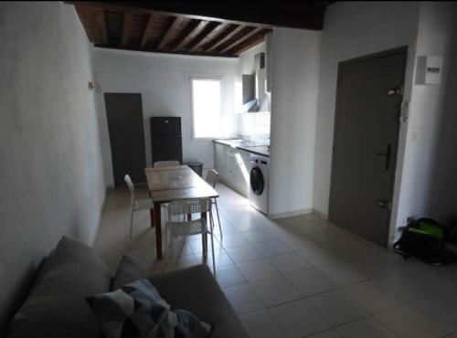 un salon avec une table et une cuisine dans l'établissement La vue du palais, à Avignon