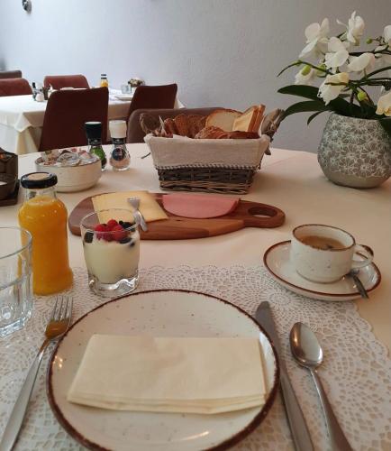 a table with plates of food and a basket of bread at Hotel Pension Oranje in Valkenburg