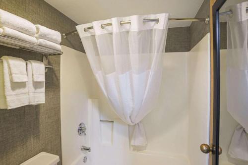 a bathroom with a shower with a white shower curtain at Stay7 studios Hotel Phoenix Metro in Phoenix
