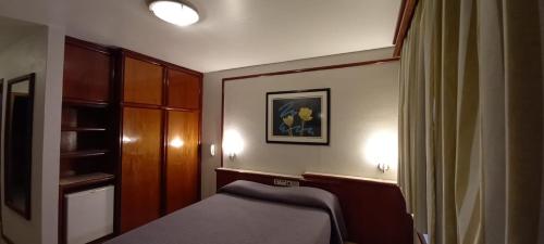 a small room with a bed and a closet at San Bernardo Park Hotel in Vacaria