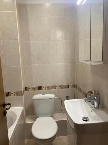 a bathroom with a white toilet and a sink at Pirin Golf Hotel Private Studios - Sani, Bansko in Razlog