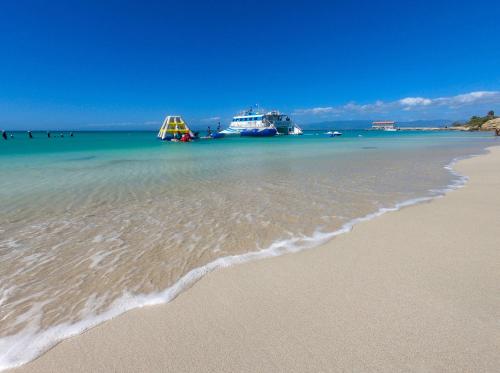 a beach with two boats in the water at Spacious Retreat with Private Jacuzzi and Terrace in Ponce