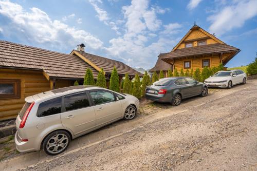a group of cars parked in front of a house at Wellness Drevenica Zuberec in Zuberec