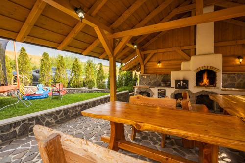 an outdoor patio with a wooden table and a fireplace at Wellness Drevenica Zuberec in Zuberec