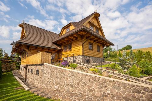 a large wooden house on top of a stone wall at Chalet Zuberec, 5 apartments, jacuzzi, sauna, mountains in Zuberec