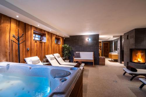 uma sala de estar com uma banheira e uma lareira em Chalet Zuberec, 5 apartments, jacuzzi, sauna, mountains em Zuberec
