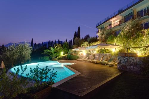 a swimming pool in front of a building at night at Hotel Maximilian in Malcesine