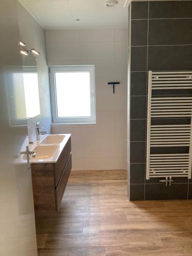 a bathroom with a sink and a window at Zonnehoeve vakantiehuizen in Hollum