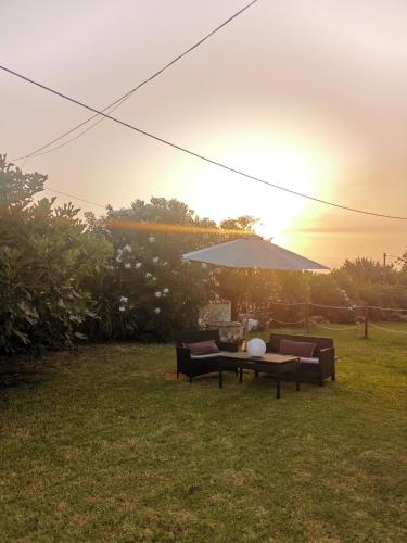 a table and chairs and an umbrella in a yard at Sungate Villas in Almiros Beach