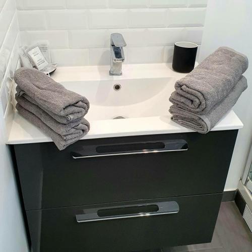 La salle de bains est pourvue d'un lavabo et de serviettes. dans l'établissement G1 Le Kiwitier - corporate apartment closest Innovel&Noveos, à Clamart