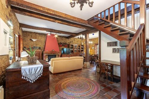 a living room with a staircase and a dining room at Caserio Urikosolo in Bilbao