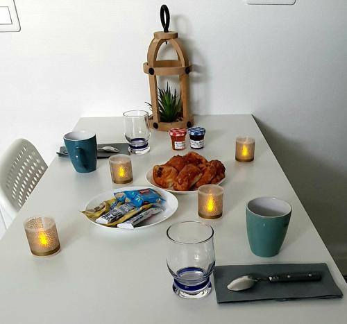 - une table avec une assiette de nourriture et des bougies dans l'établissement G1 Le Kiwitier - corporate apartment closest Innovel&Noveos, à Clamart