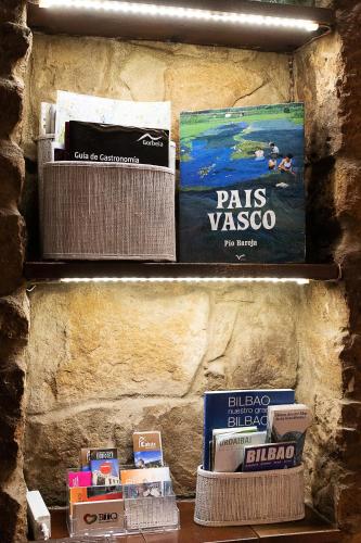a book shelf with some books on it at Caserio Urikosolo in Bilbao