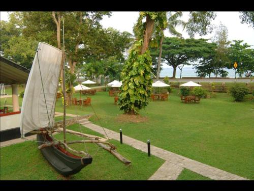 a boat on display in a garden with tables and chairs at EKHO Weligama in Weligama