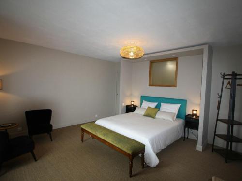 1 dormitorio con 1 cama blanca grande y 1 silla en Gîte Étival-Clairefontaine, 3 pièces, 5 personnes - FR-1-589-379, en Étival-Clairefontaine