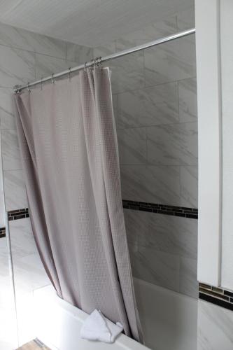 een douchegordijn in de badkamer met een bad bij Chalet Motel in Bend