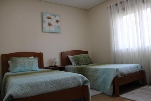 - une chambre avec 2 lits et une fenêtre dans l'établissement APARTAMENTO CIDADE NOVA, à Viana do Castelo