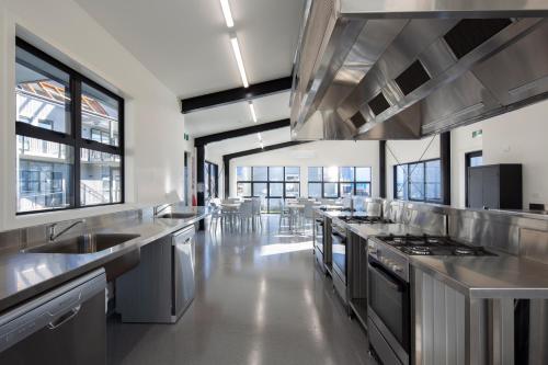 a large kitchen with stainless steel counters and sinks at Harvest Park Studios Workers Accommodation in Cromwell