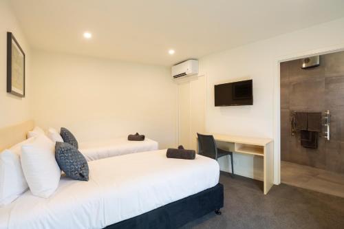 a hotel room with two beds and a desk at Harvest Park Studios Workers Accommodation in Cromwell