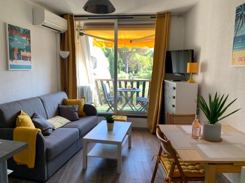 un salon avec un canapé et une table dans l'établissement Super Appart ! Terrasse, Clim, Parking, 2min Plage., à La Grande Motte