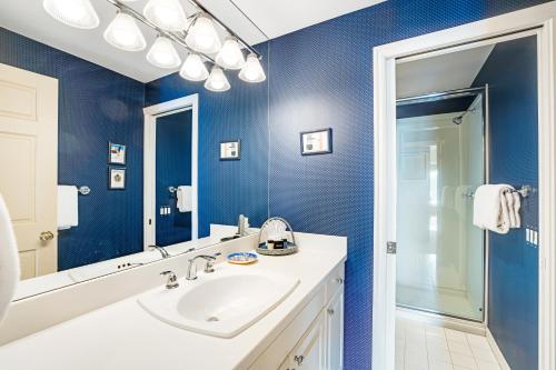 a blue bathroom with a sink and a mirror at Searidge D2 in Depoe Bay