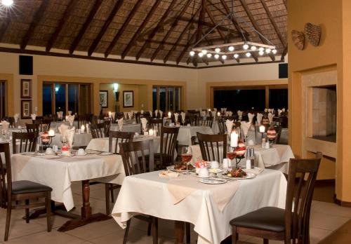 um salão de banquetes com mesas e cadeiras com toalha de mesa branca em Hannah Game Lodge em Ohrigstad
