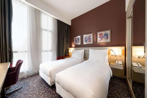 a hotel room with two beds and a desk at SAS Residence & Hotel Dhahran in Al Khobar