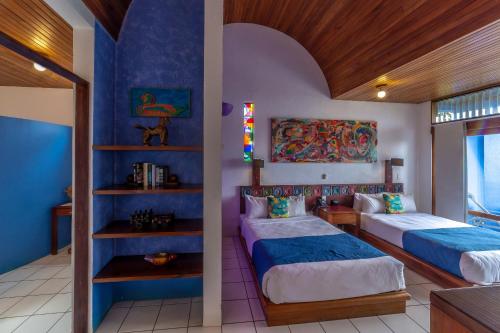 two beds in a room with blue walls at Xandari Resort & Spa in Alajuela City