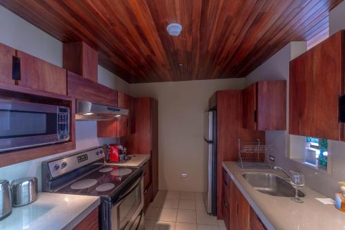 a kitchen with wooden cabinets and a stove top oven at Xandari Resort & Spa in Alajuela City