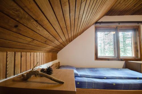 a bedroom with a bed and a wooden ceiling at Rustic Home Tara in Kaludjerske Bare