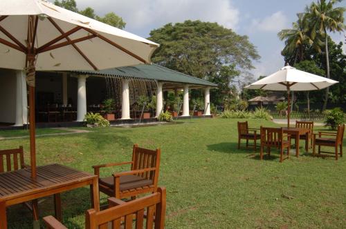 a group of tables and chairs with umbrellas at EKHO Weligama in Weligama